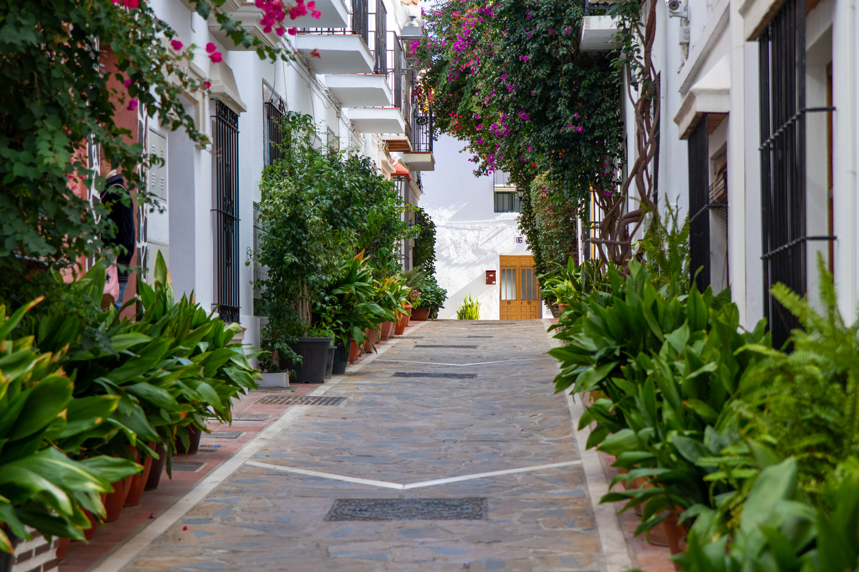 Beautiful streets of Marbella old town. Flowers, old buildings architecture. White houses , blue sky