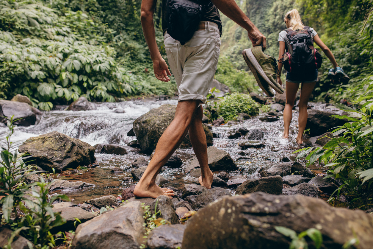 Couple crossing the stream barefooted