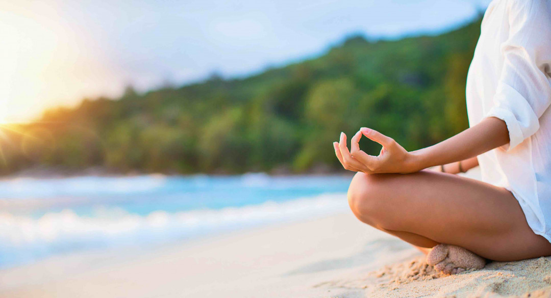 Closeup of Woman's Practicing Lotus Pose on the Beach at Sunset